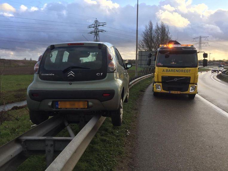 Oops! Motorist 'parks' perfectly on the barrier of highway