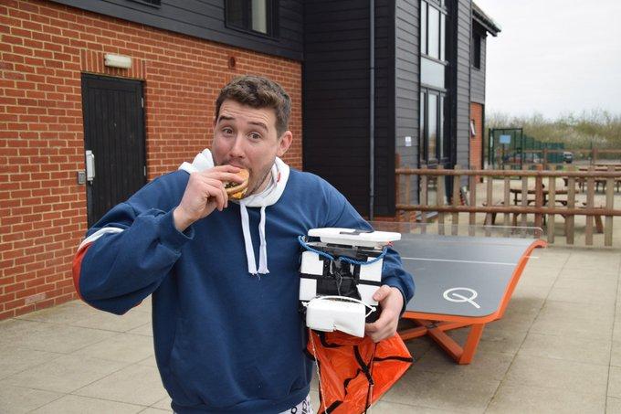 Soccer players find box from space with hamburger on the field