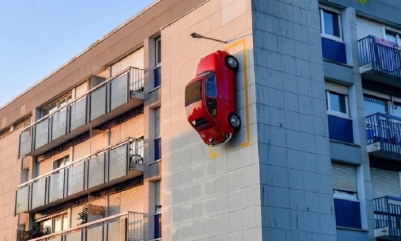 Red Fiat 500 parked on the facade of a building