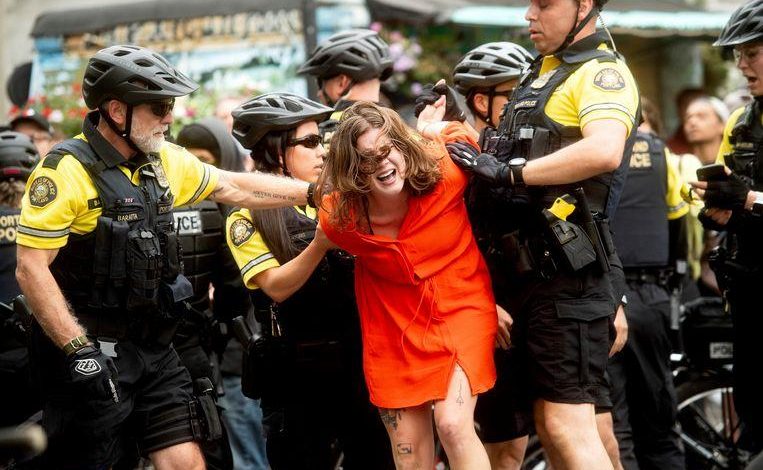 Woman spits in the direction of the police. 5 agents work hard on her