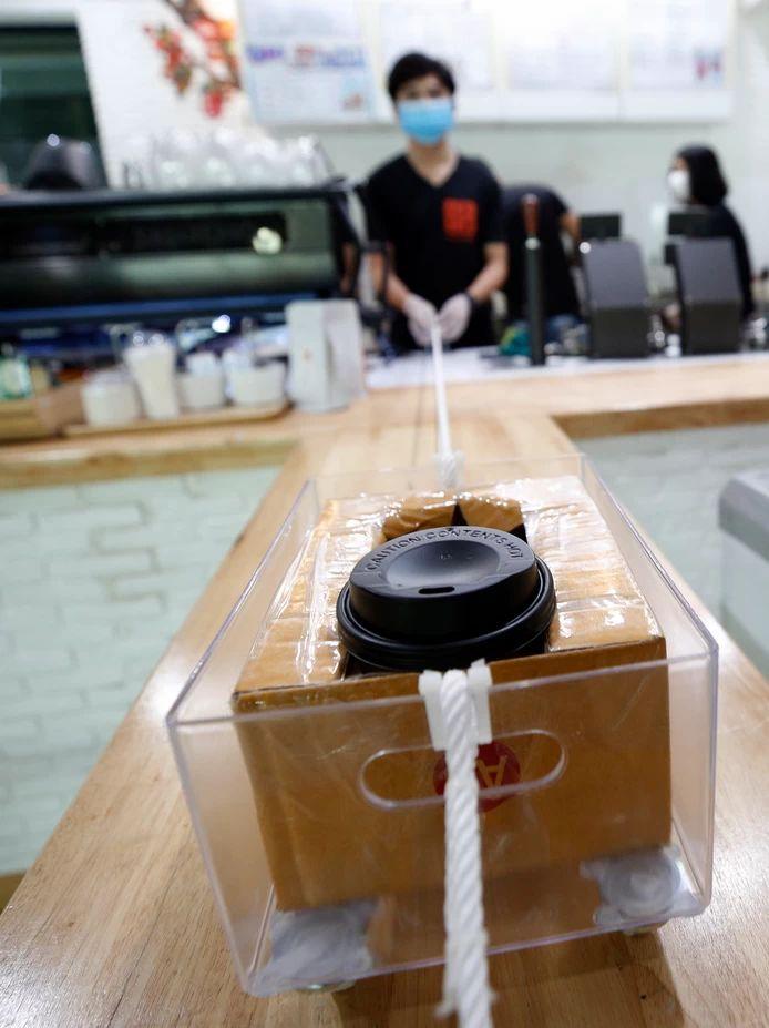 In coffee bar Art of Coffee in Bangkok, keeping your distance is sacred. Employees have devised an ingenious system to provide customers with a cup of coffee.