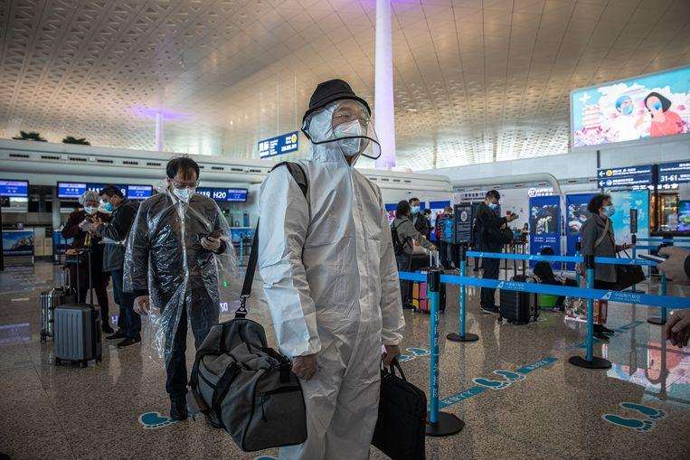 Passengers appear in protective suits
