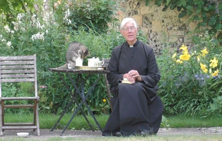 While Priest is preaching, cat is seriously lapping his milk 
