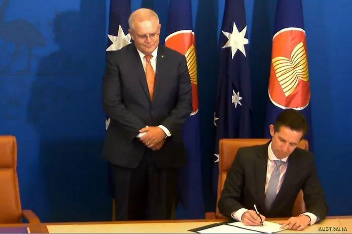 Australia was not missing either. Prime Minister Scott Morrison watches as Secretary of Commerce Simon Birmingham signs.