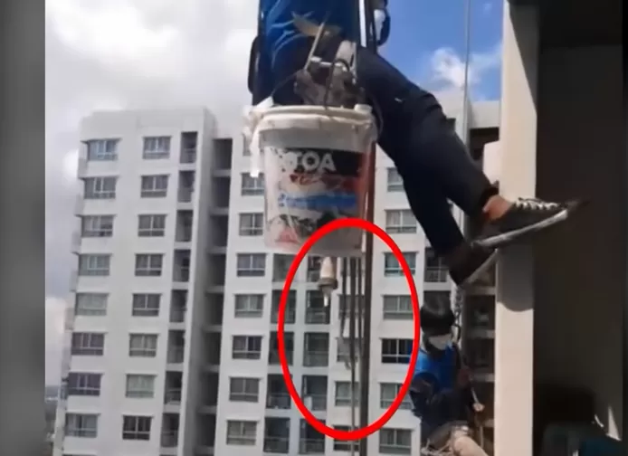 A resident of the apartment building cut the painters' support ropes while the men were carrying  out repairs. © Screenshot YouTube/Thairath Online
