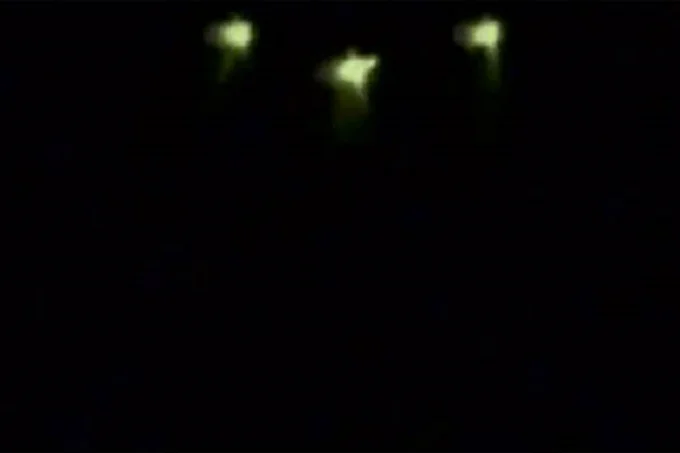 A picture taken by Nikita Tomin, shows three green-shaded lights on a UFO flying above a lakeside resort in Irkutsk region.