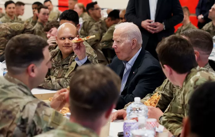 US President Joe Biden eats pizza as he meets with US Army soldiers assigned to the 82nd Airborne Division at the G2 Arena in Jasionka, near Rzeszow, Poland, March 25, 2022.