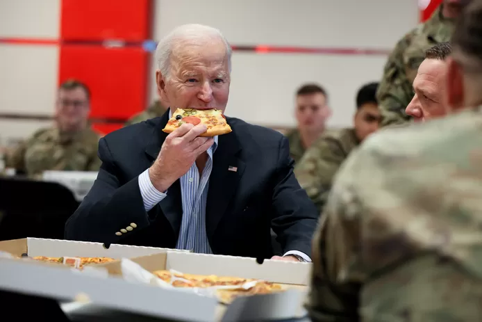 US President Joe Biden eats pizza as he meets with US Army soldiers assigned to the 82nd Airborne Division  at the G2 Arena in Jasionka, near Rzeszow, Poland, on March 25, 2022.