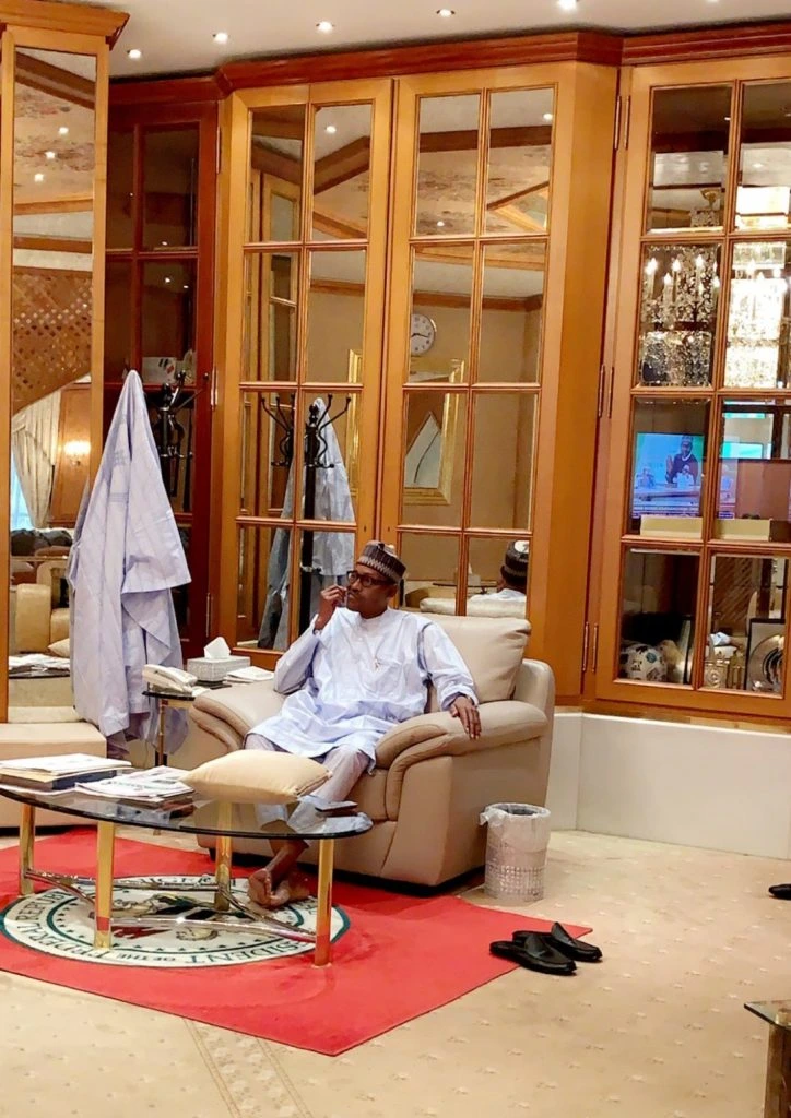 President Buhari on a couch, apparently after a meal, picking his teeth
