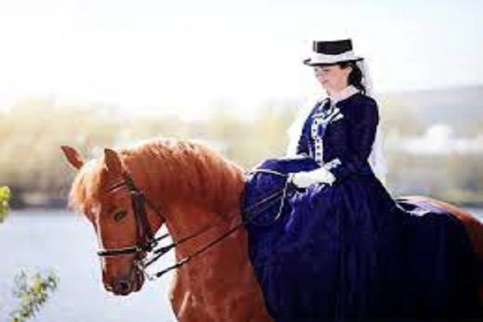A lady riding a horse on a sidesaddle
