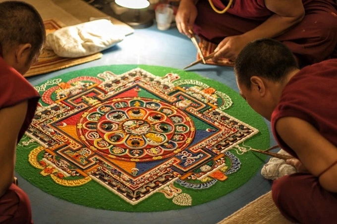 The process of building huge sand mandalas is usually worked on by several monks