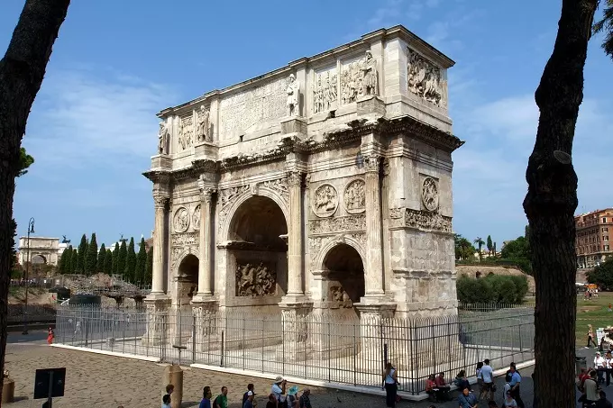 The Arch of Constantine stands in the shadow of the Colosseum in Rome, Italy.