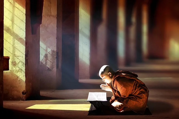 A monk engaging in the practices of reading sacred texts