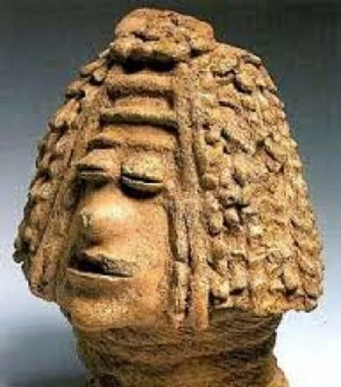 ceramic figure of a “Luzira man” with a long nose and a hairstyle resembling a judicial wig