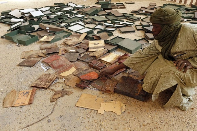 A museum guard inspects damaged manuscripts in Timbuktu