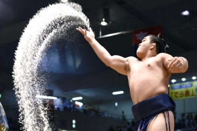 Sumo wrestlers throw salt into the ring